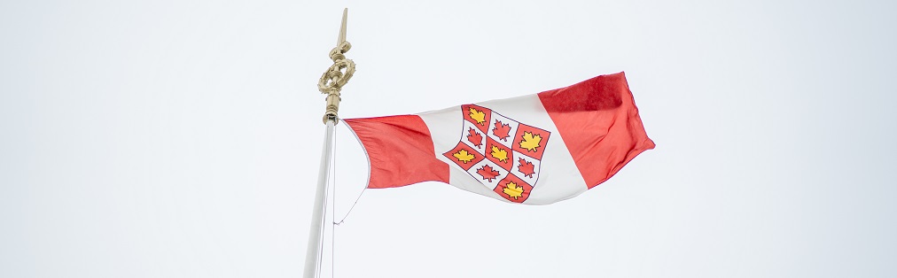 Le drapeau de la Cour suprême du Canada qui flotte devant le ciel