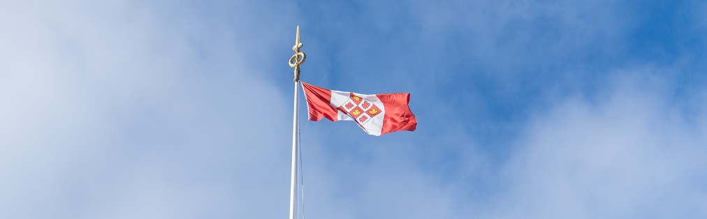 Le drapeau de la Cour suprême du Canada qui flotte devant un ciel bleu