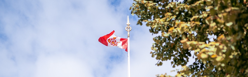 Le drapeau de la Cour suprême du Canada qui flotte devant un ciel bleu