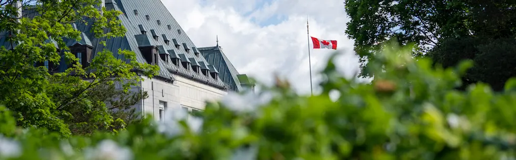 The Canadian flag flying in front of the Supreme Court of Canada building