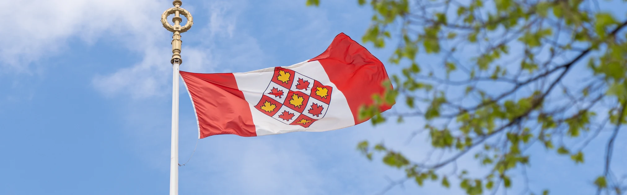 Le drapeau de la Cour suprême du Canada qui flotte devant un ciel bleu
