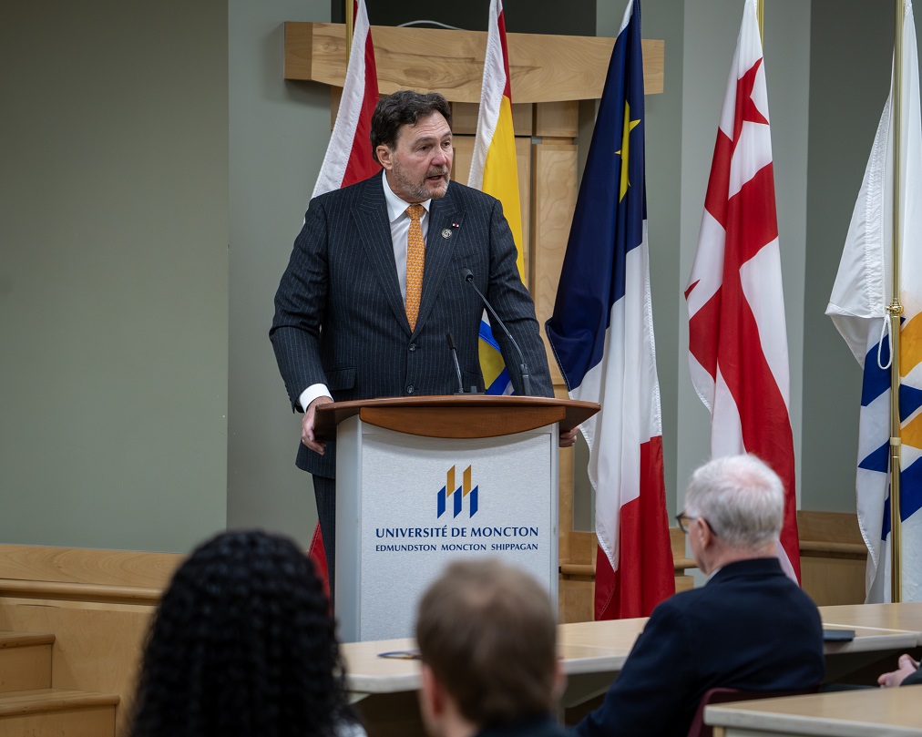 Le juge en chef Richard Wagner debout à un podium à l’Université de Moncton