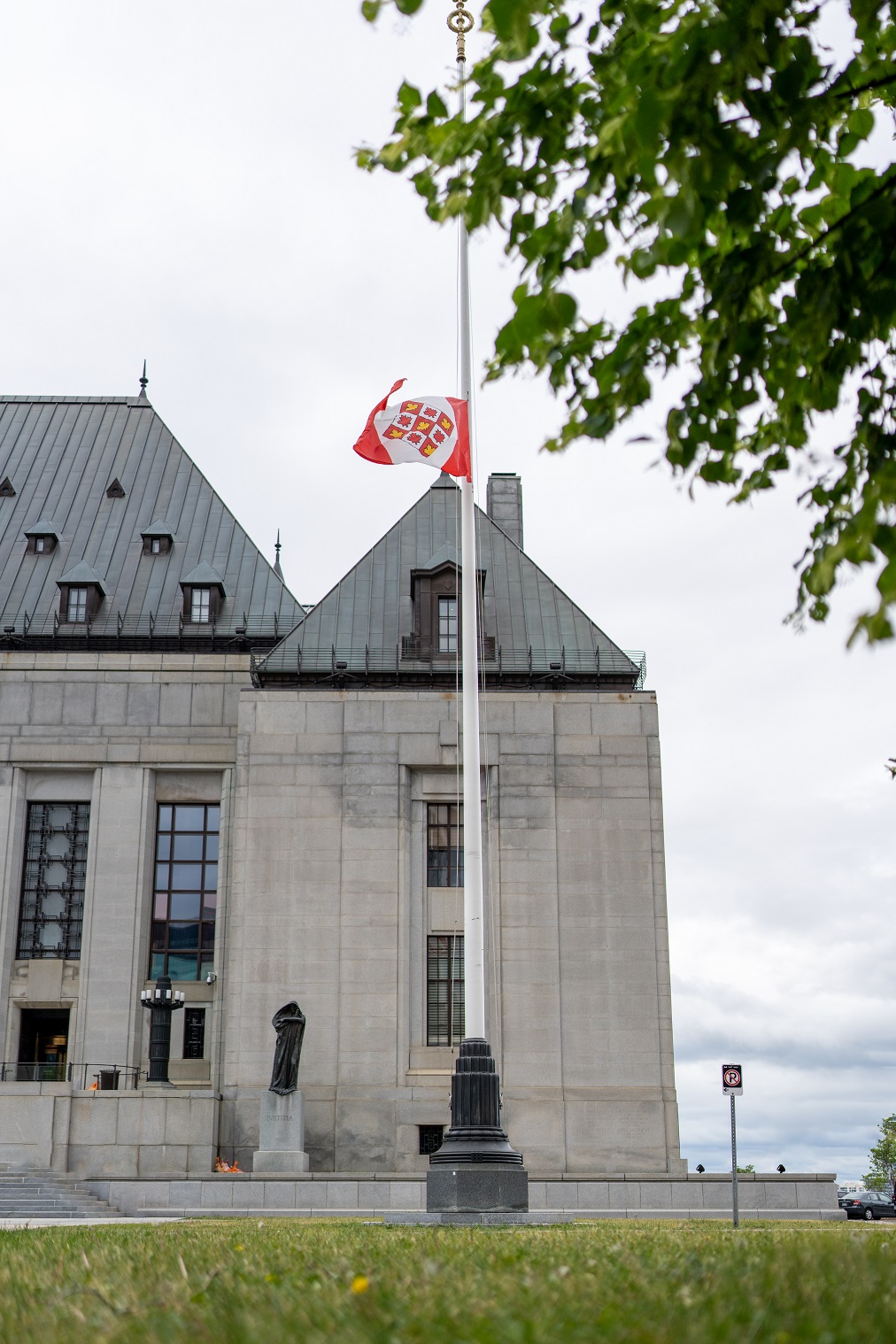 Le drapeau de la Cour suprême du Canada en berne devant l’édifice de la Cour