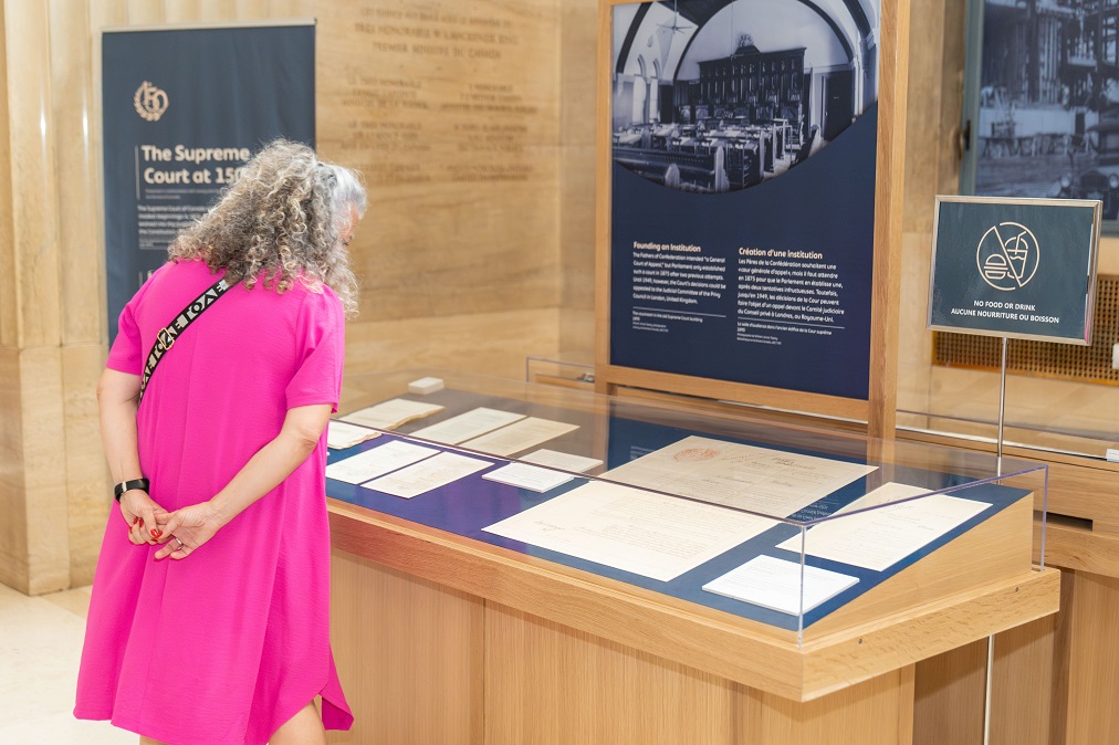 Une visiteuse regarde une exposition de documents dans le hall d’honneur de la Cour suprême