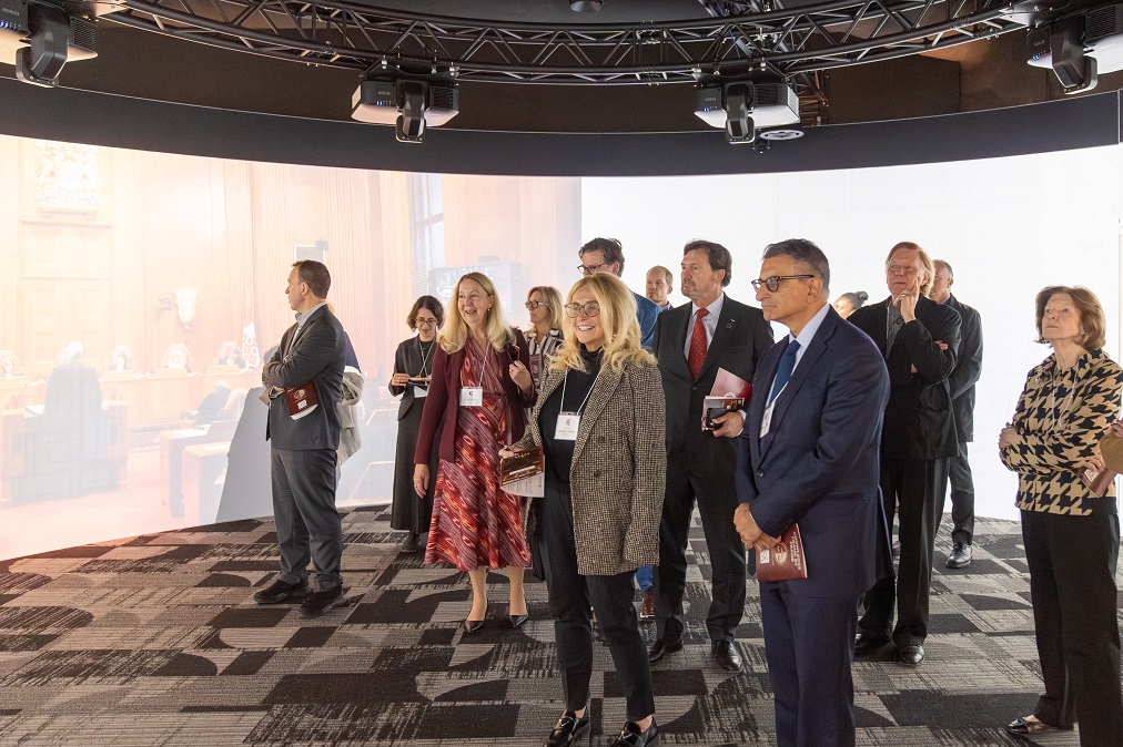 Les juges et d’autres participants regardent une vidéo sur un écran immersif à 360 degrés