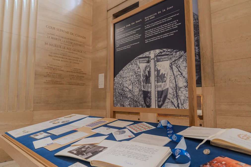 Un présentoir dans le hall d’honneur qui contient des livres, des timbres, des pièces de monnaie et des photographies