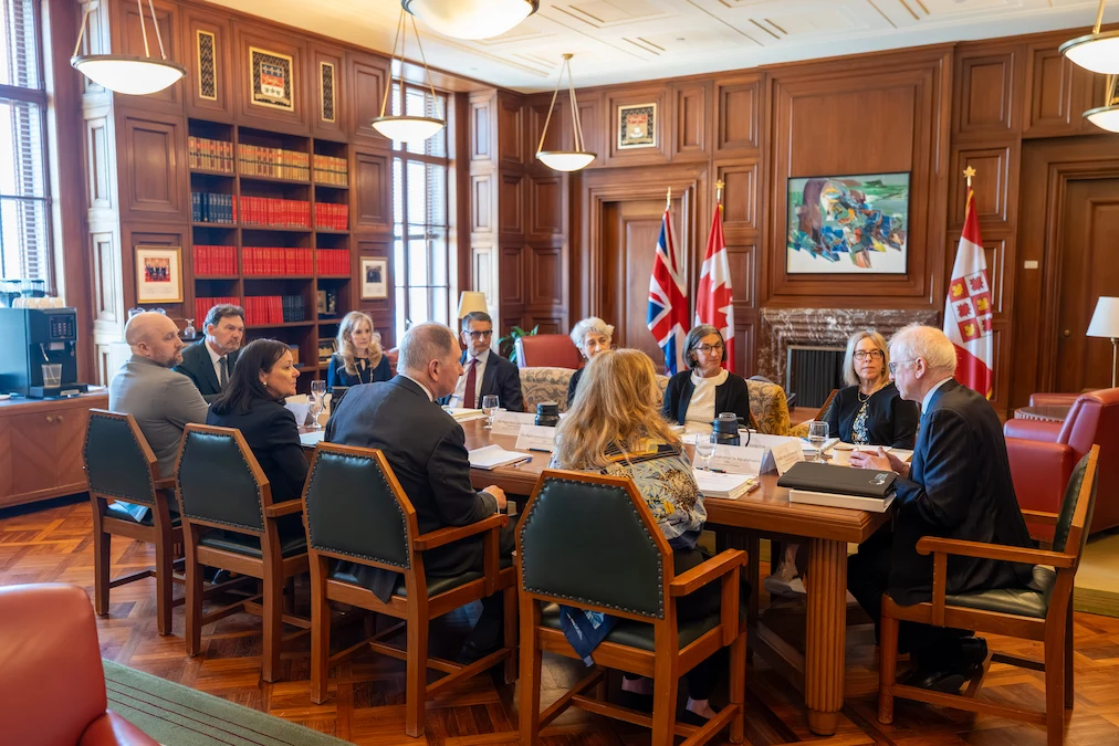 Les délégations de la Cour suprême du Canada et de la Cour suprême du Royaume-Uni assis autour d’une table de conférence
