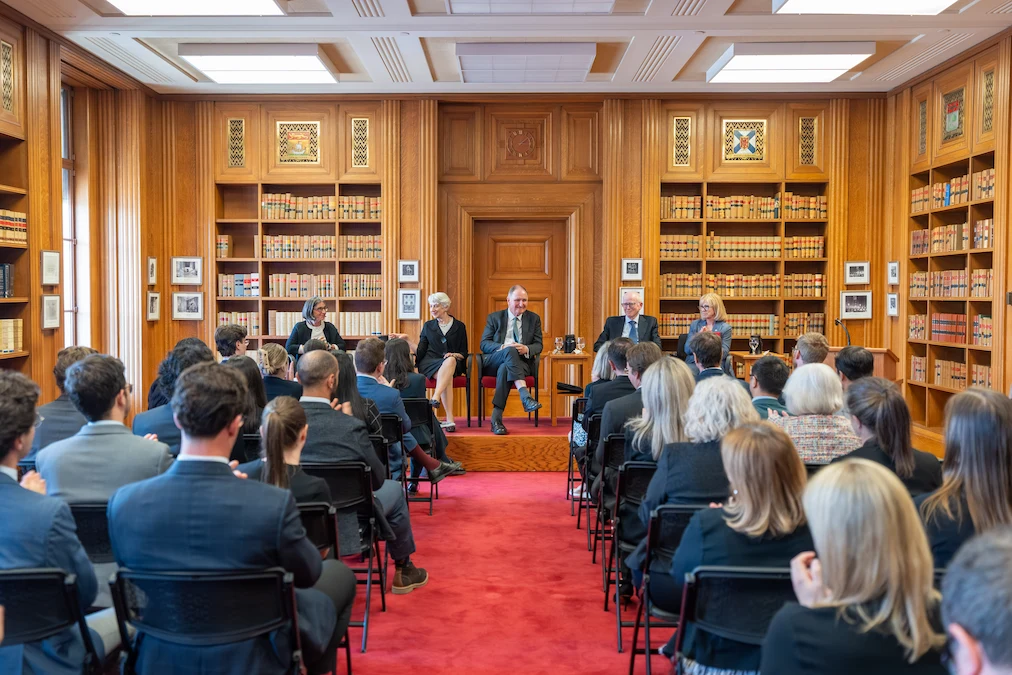 La délégation de la Cour suprême du Royaume-Uni assis sur une estrade tandis que les employés écoutent