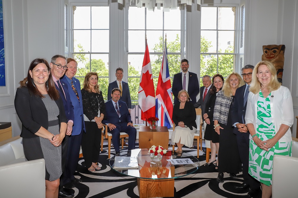 Les juges de la Cour suprême posent pour une photo avec divers dignitaires, devant des drapeaux canadiens et britanniques