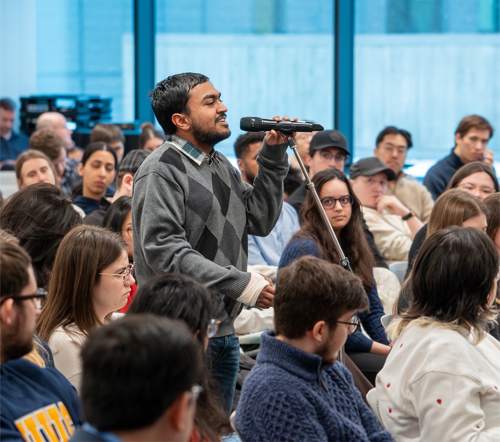 Un étudiant dans l’auditoire parle dans un microphone