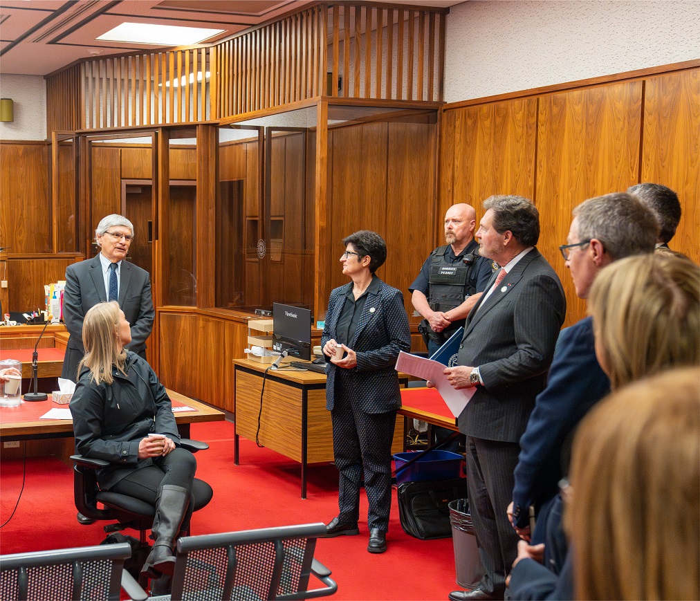 Le juge en chef Wagner, le juge Kasirer et des représentants de la Cour suprême discutent avec des membres du personnel dans une salle d’audience