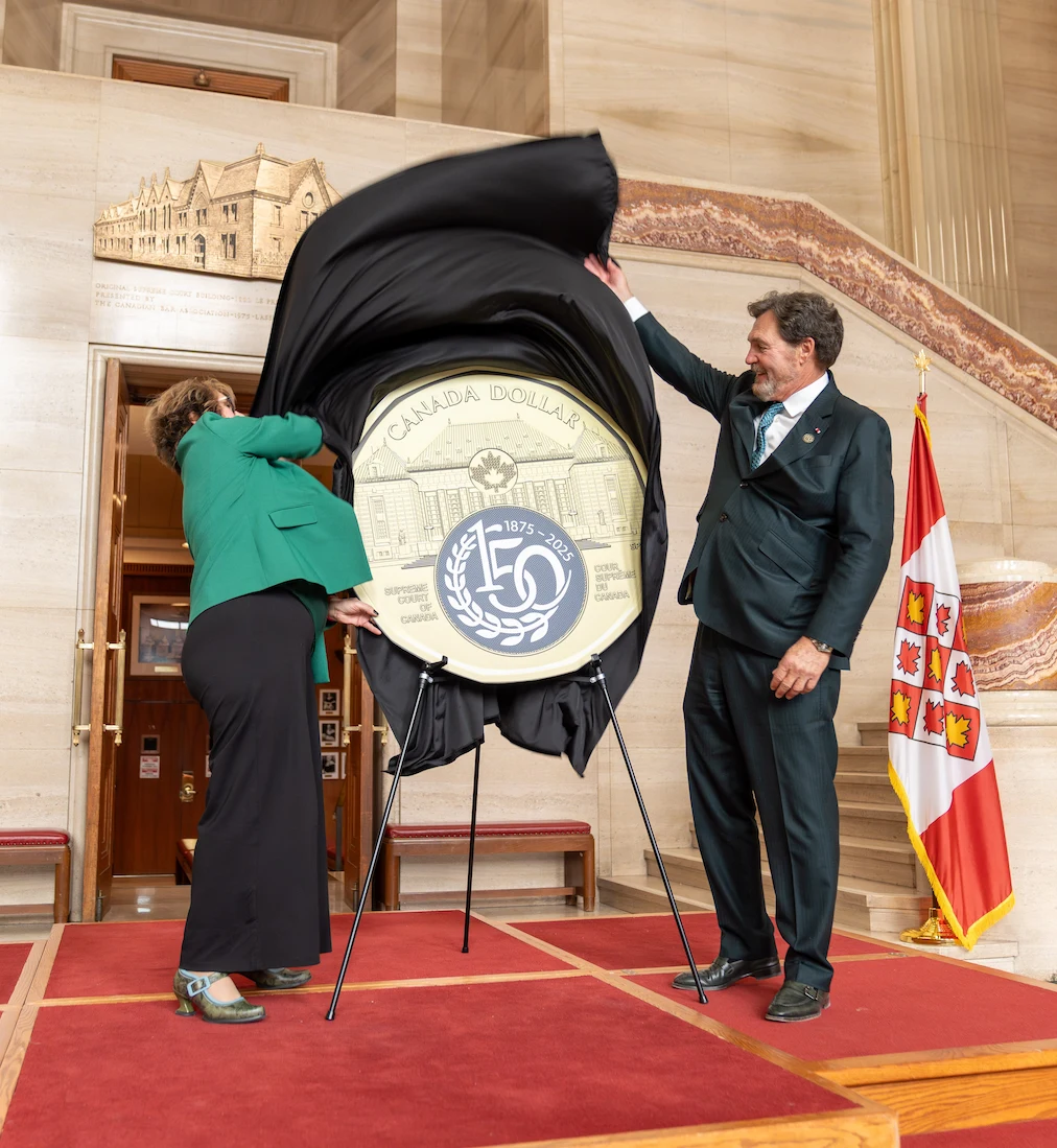 Le juge en chef Wagner et la présidente de la Monnaie royale canadienne Marie Lemay dévoilent une copie surdimensionnée de la pièce de 1 $