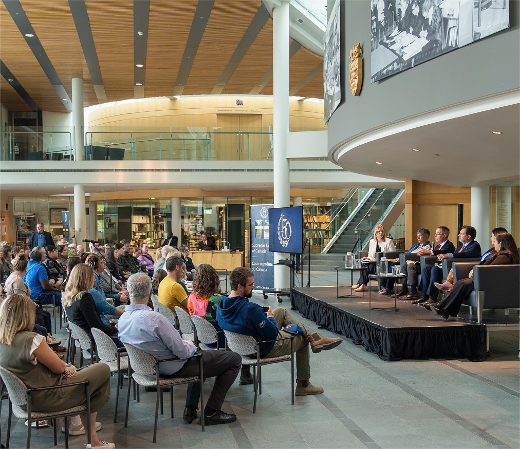 Les juges assis sur une scène devant un auditoire dans un grand atrium