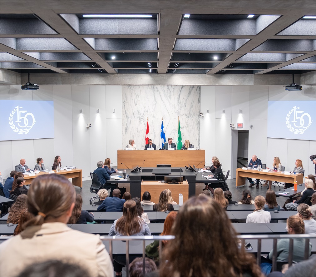 Les juges assis sur une estrade devant un auditoire dans un grand auditorium