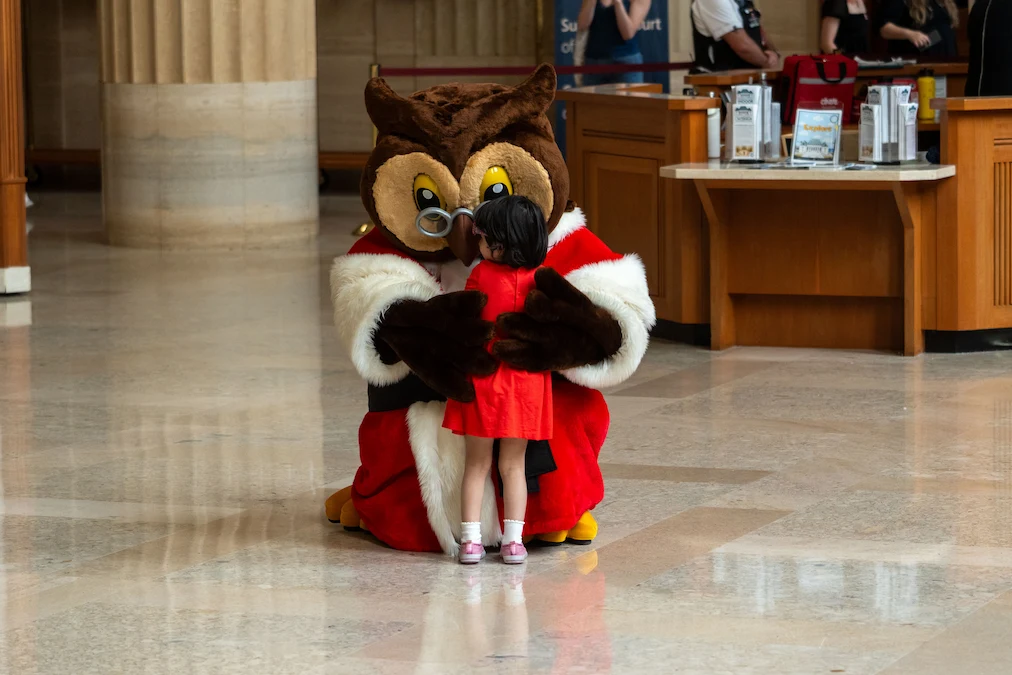 Amicus, la mascotte de la Cour, serre une petite fille dans ses bras